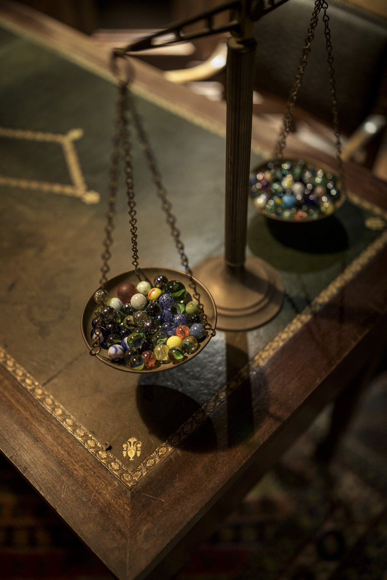 Marbles hanging in vintage reclaimed metal scales