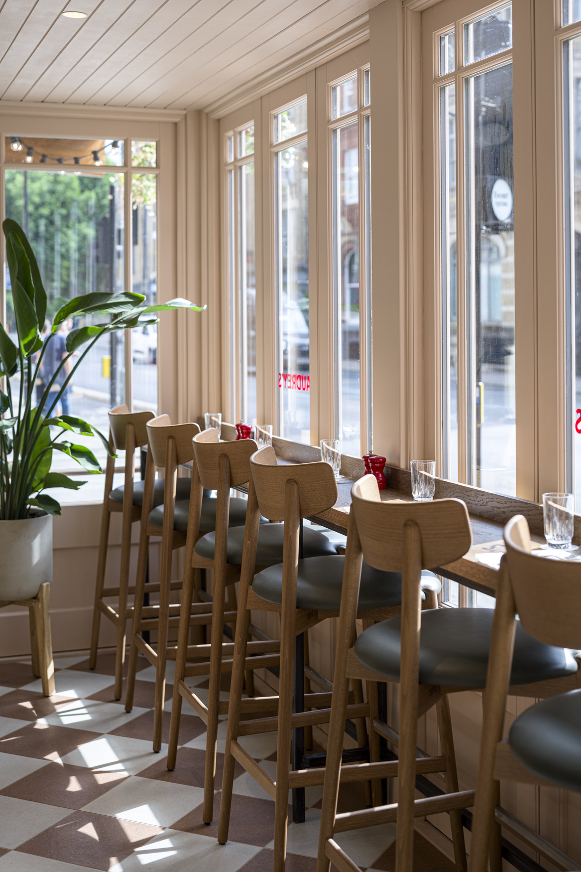 Audrey's Cafe & Bar Borough modern and retro restaurant designed by 3Stories Interior Design and branding creative agency London, featuring a row of high seating chairs and large windows