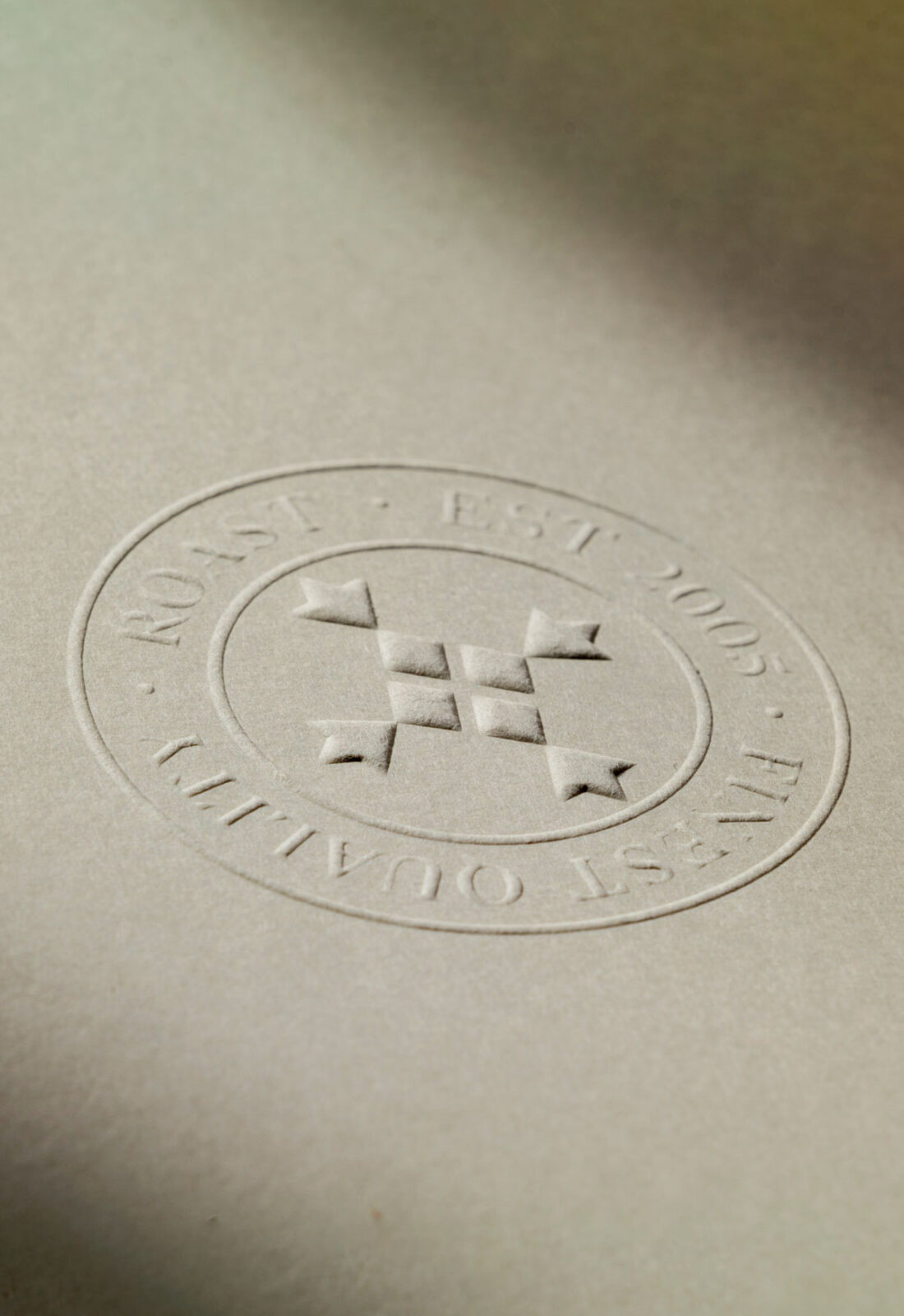 Detail of logo, crest, seal of quality embossed on paper, modern, traditional british and unique brand identity for Roast Borough Market designed by 3Stories Interior Design and Branding creative agency London